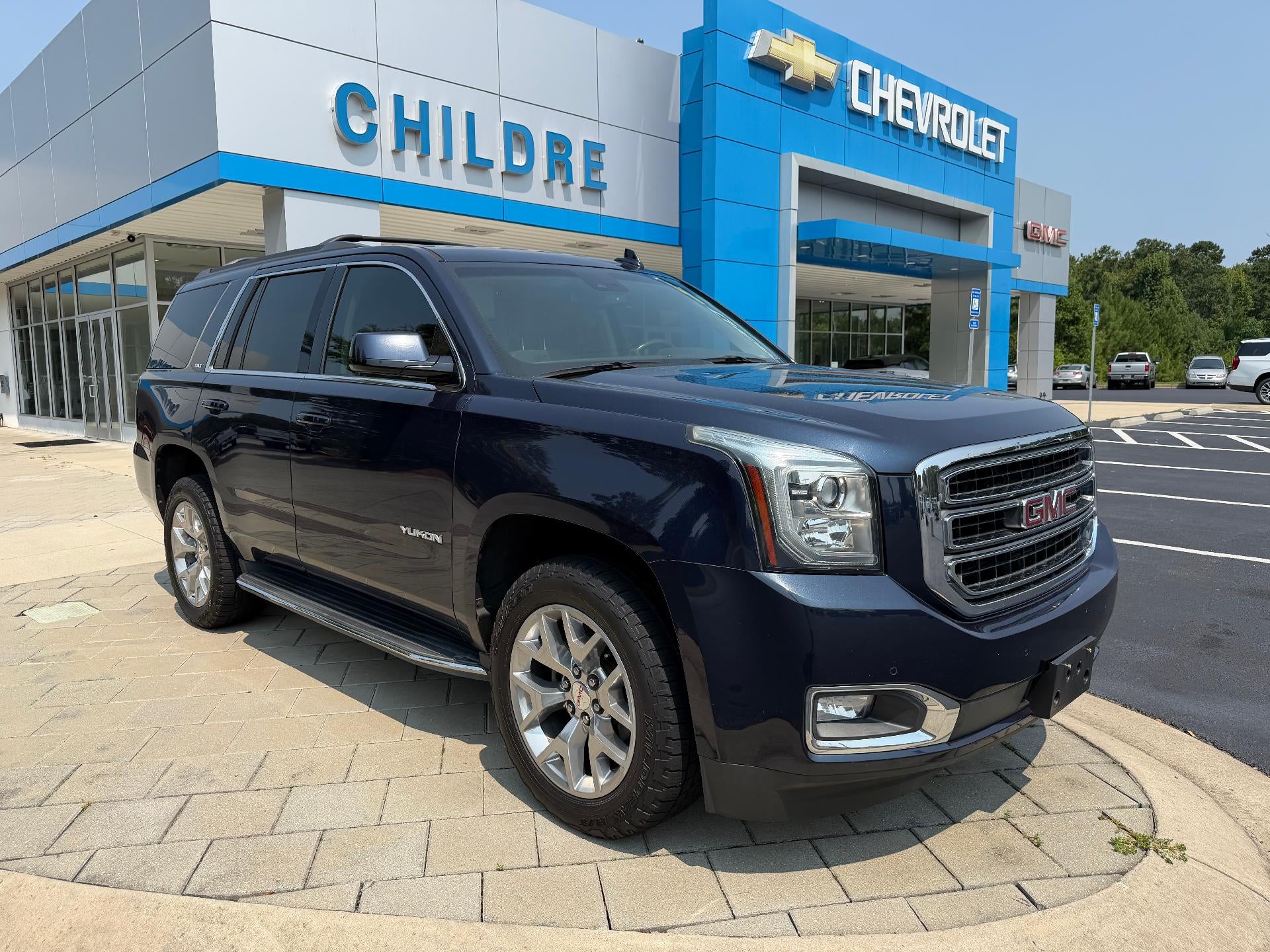 2019 GMC Yukon SLT in Dark Sapphire Blue Metallic — front three-quarter view